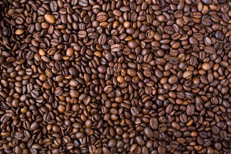 A detailed view of medium roast coffee beans, rich in texture and color.